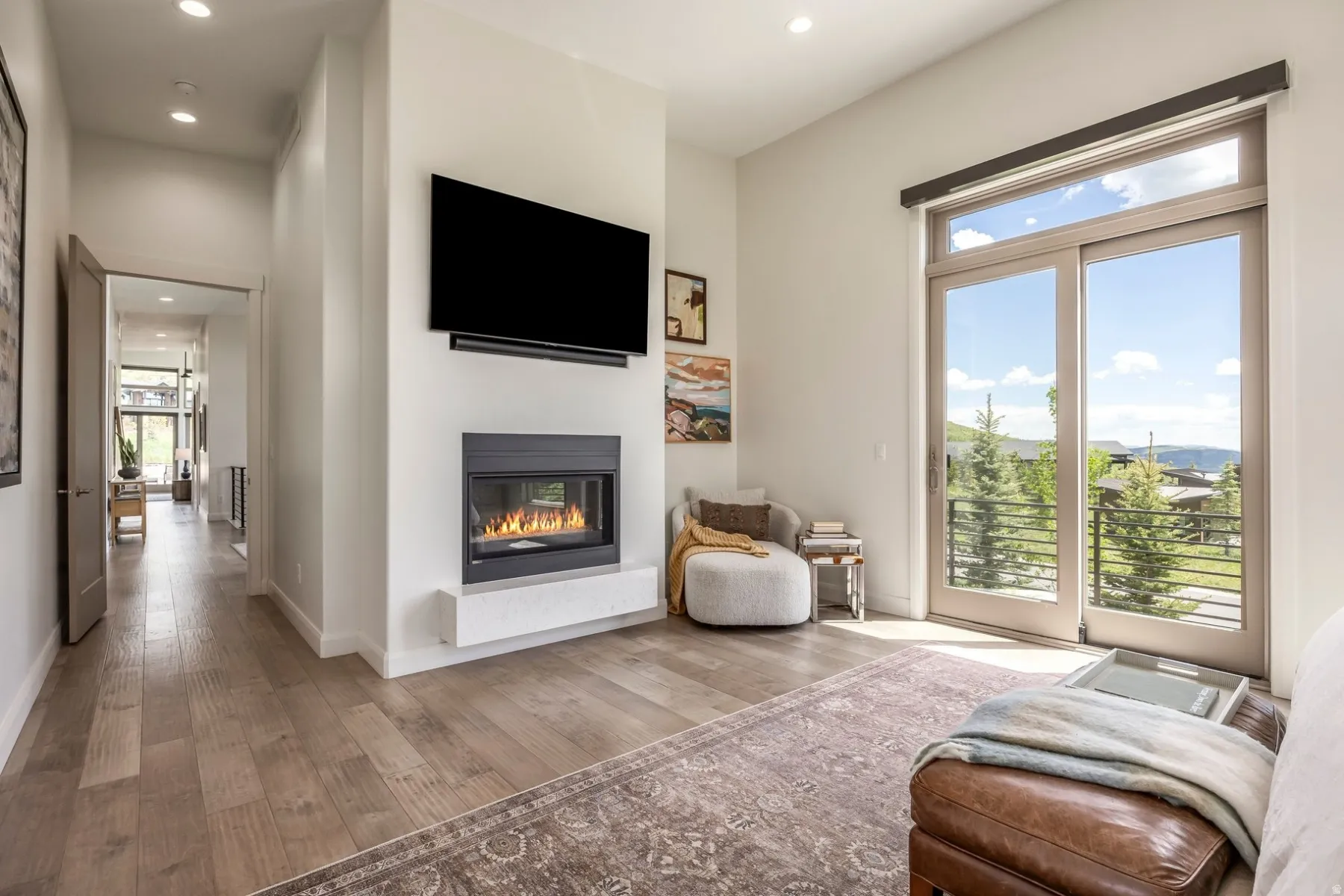 Built-in fireplace with hearth, wood-finish flooring, glass sliding doors, and recessed lighting