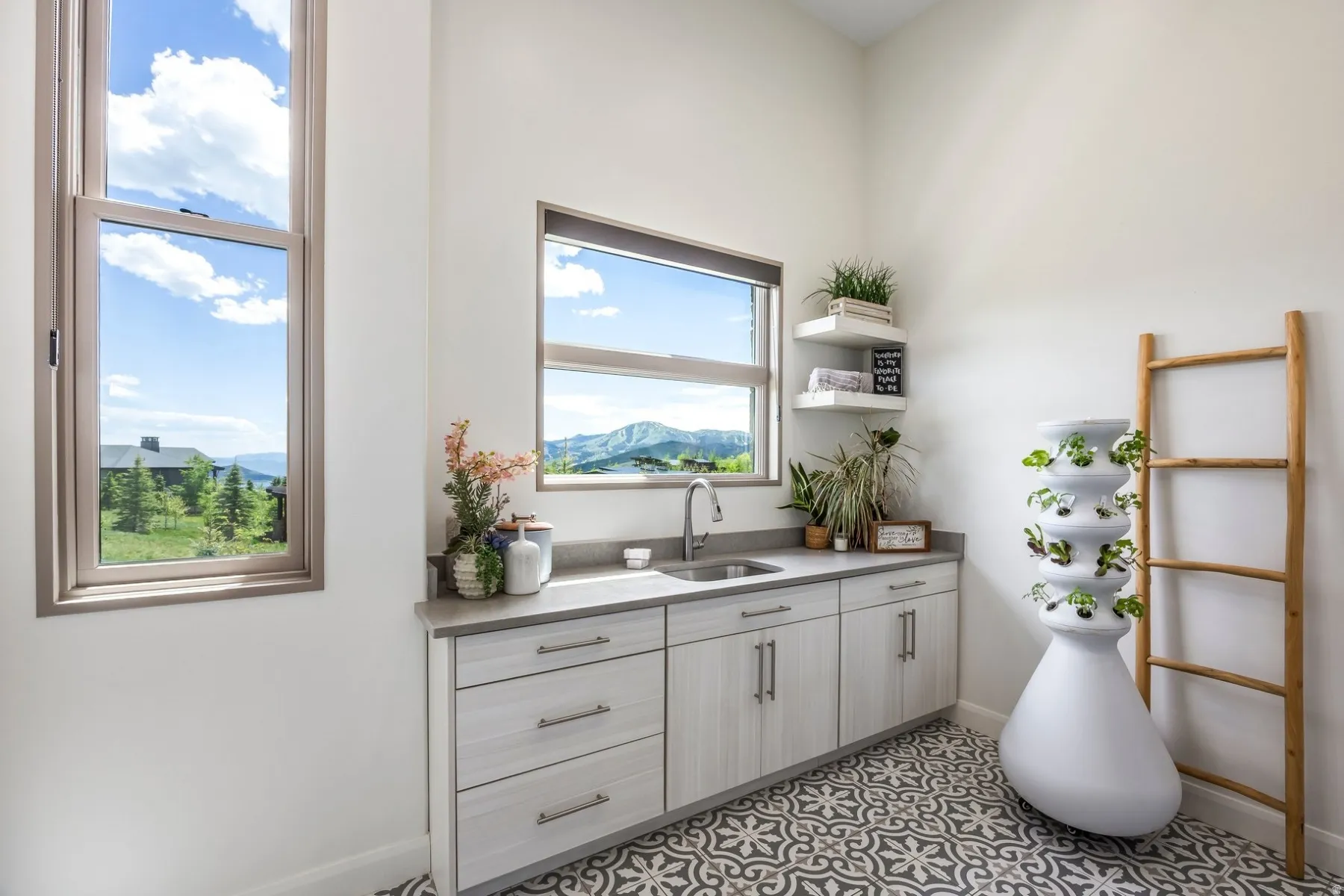 Built-in cabinetry with modern hardware, integrated sink with stainless steel faucet, and patterned floor tile