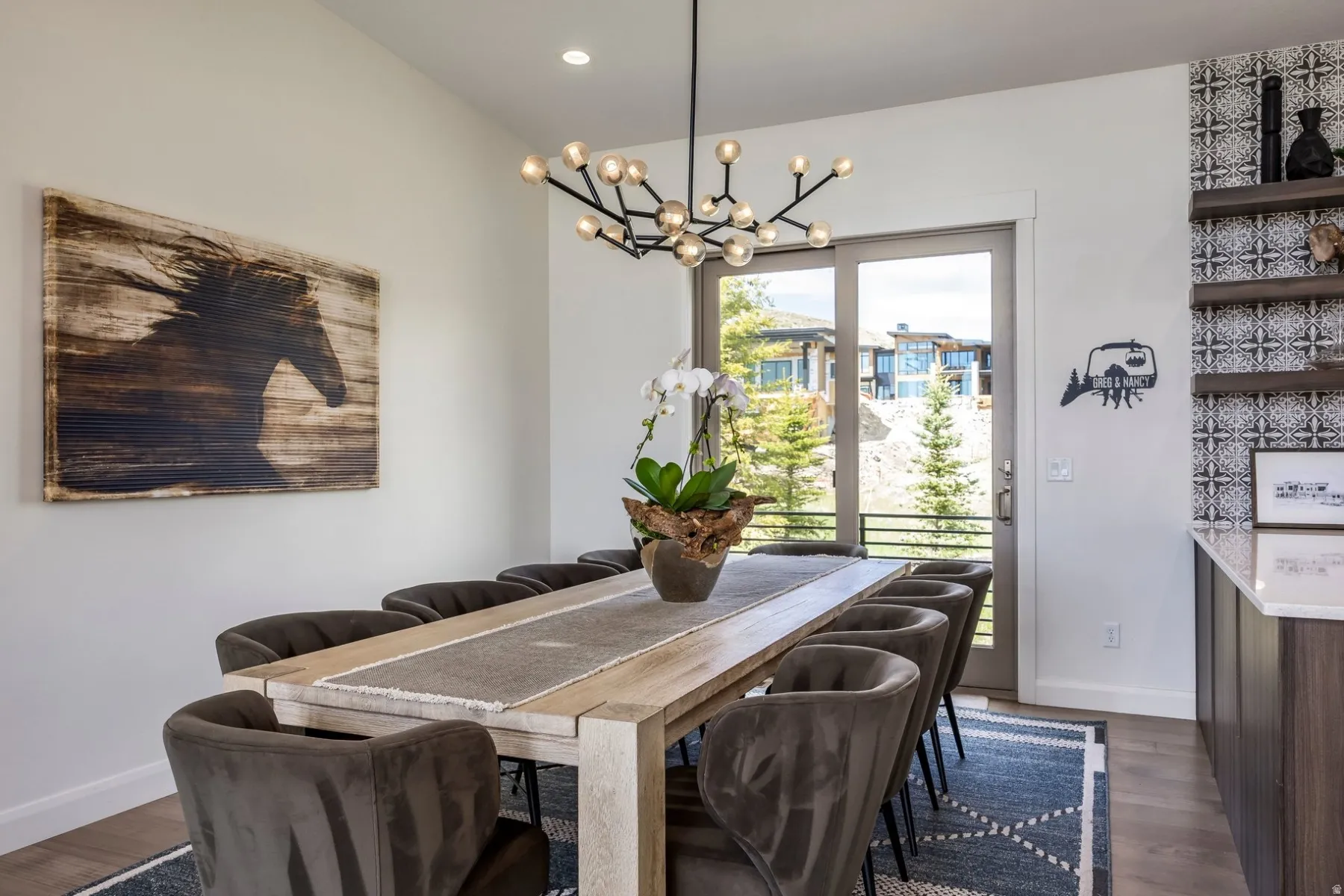 Dining area with wood-finish flooring, a modern linear chandelier, and sliding glass doors