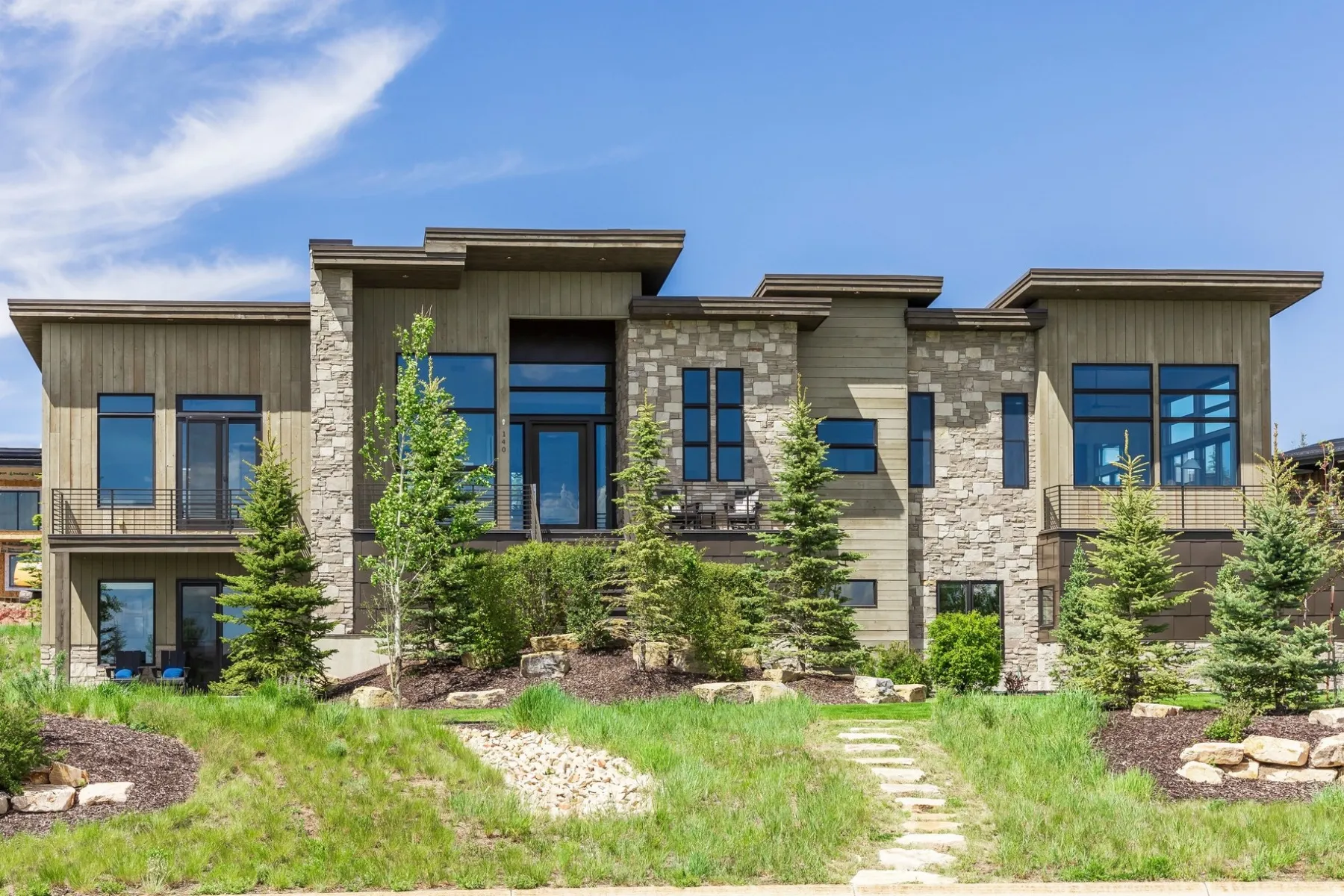 Contemporary exterior featuring stone and vertical wood siding