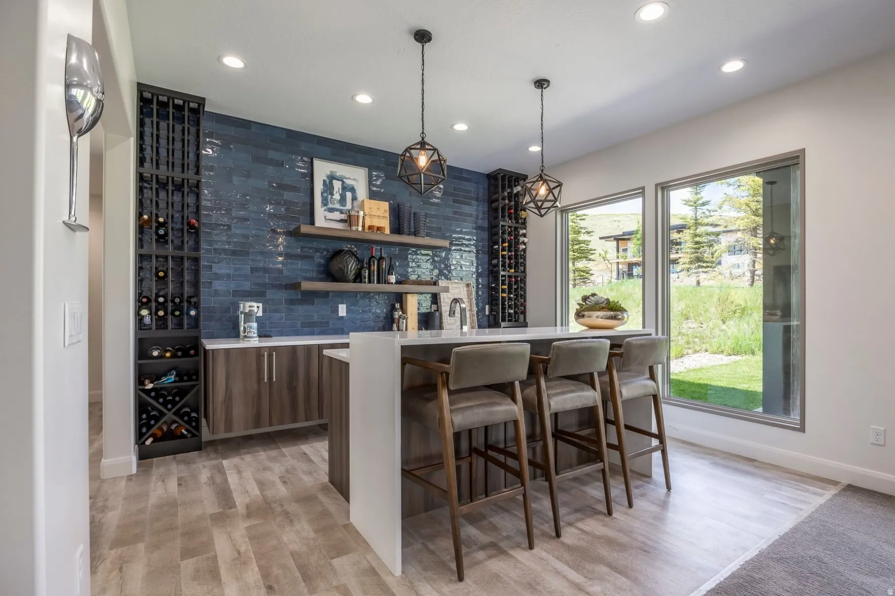 Custom built-in wine storage, wood-finish flooring, recessed lighting, expansive windows, and a built-in wet bar with shelving