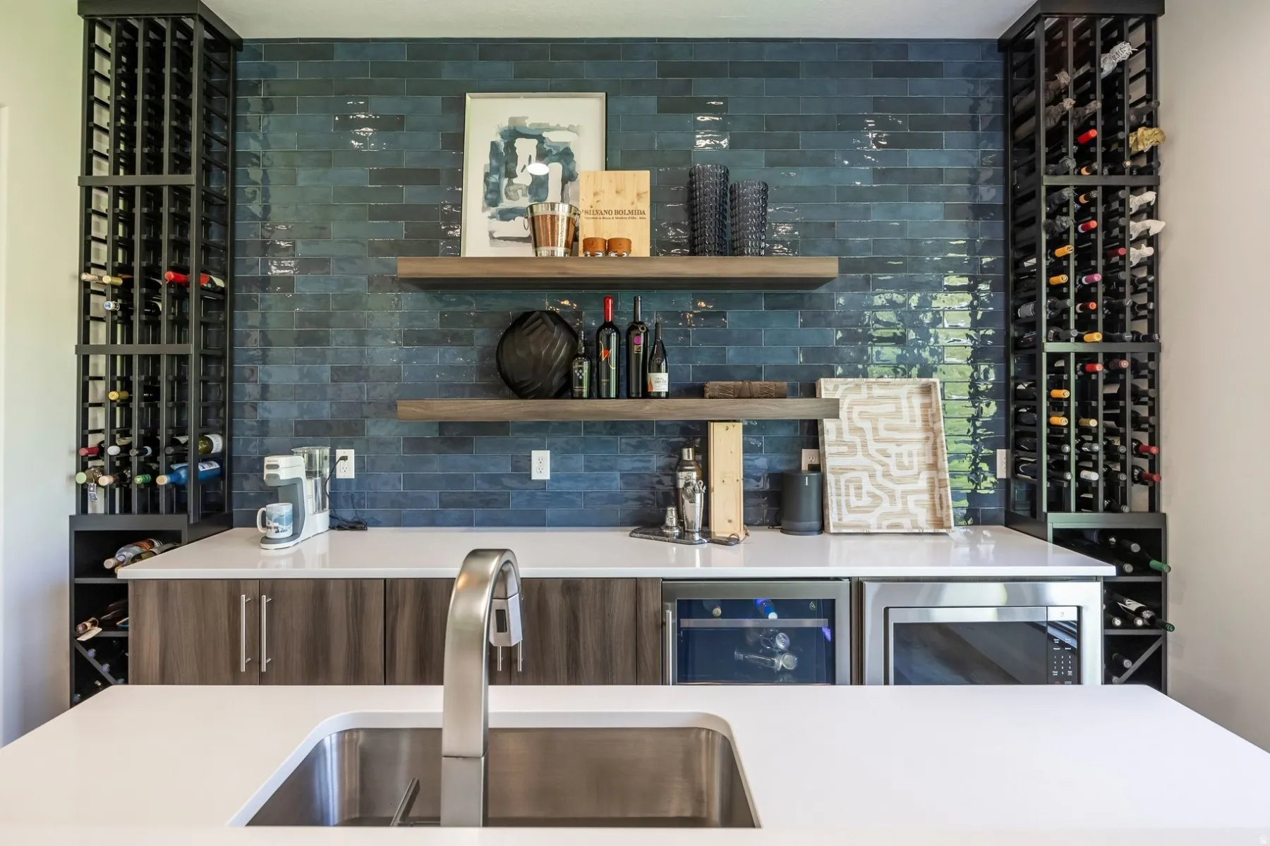 White countertops with an undermount stainless steel sink and a brushed nickel faucet