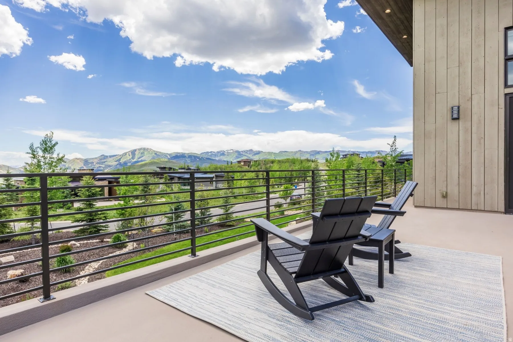 Outdoor balcony with horizontal bar railing and mountain scenery