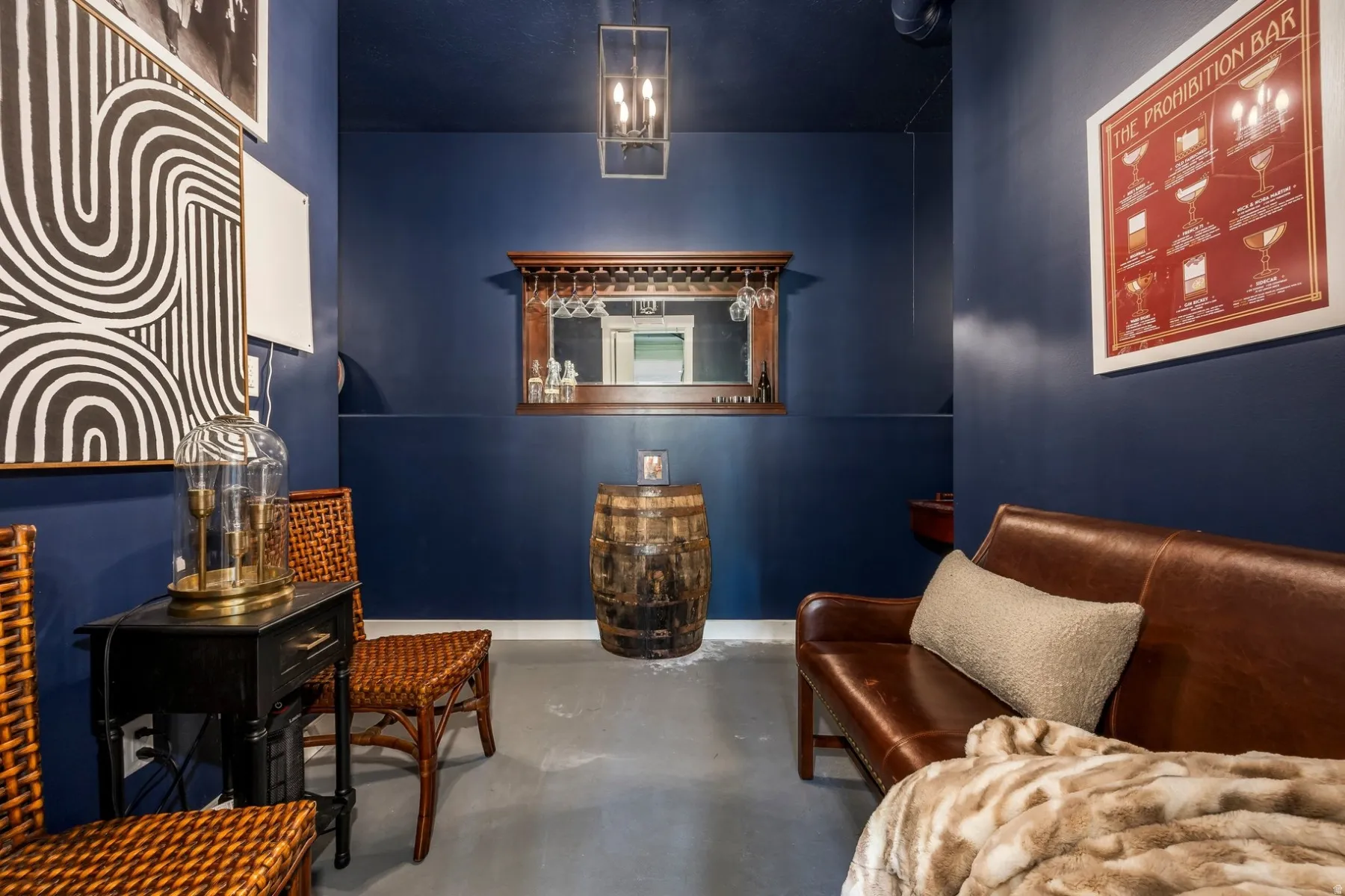 Recessed lighting, dark blue wall finish, wine glass rack, mirror, and concrete flooring