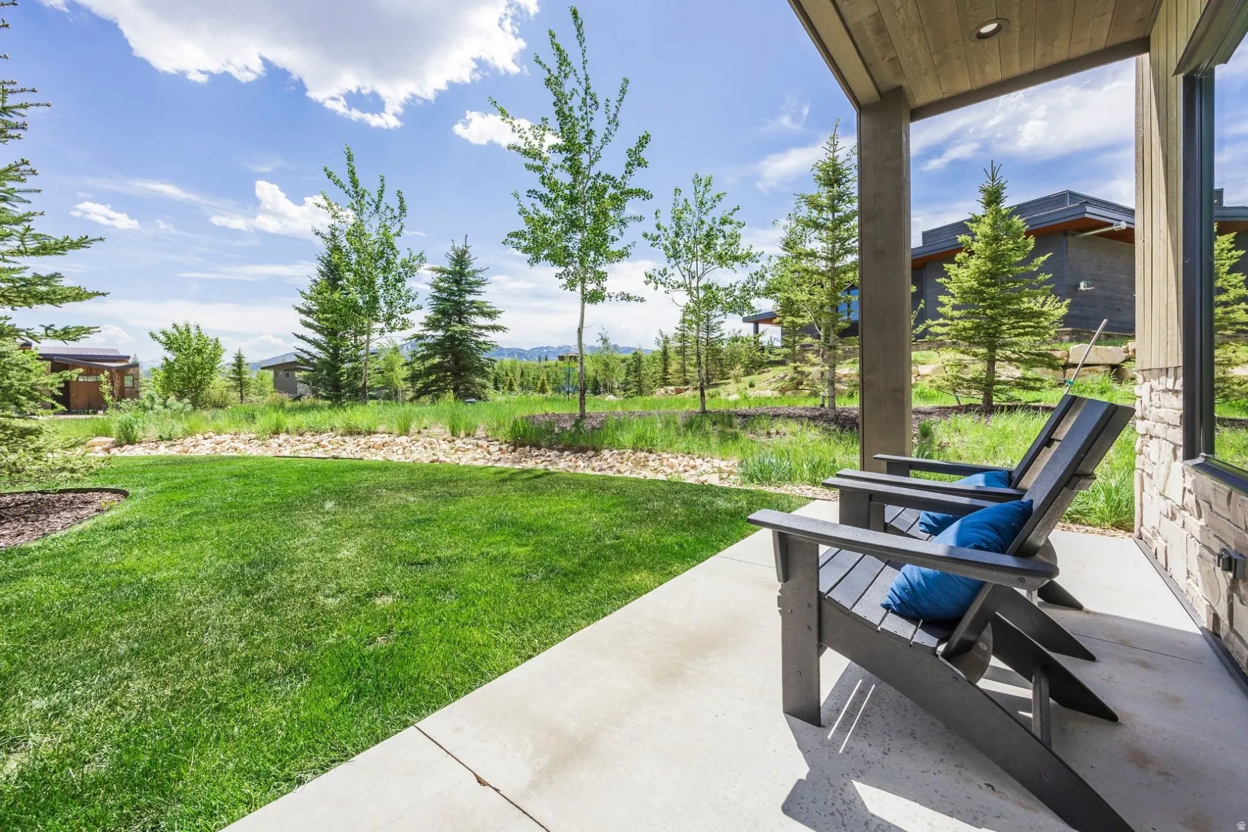 Covered patio with a concrete surface, stone exterior wall, and wood-finish ceiling
