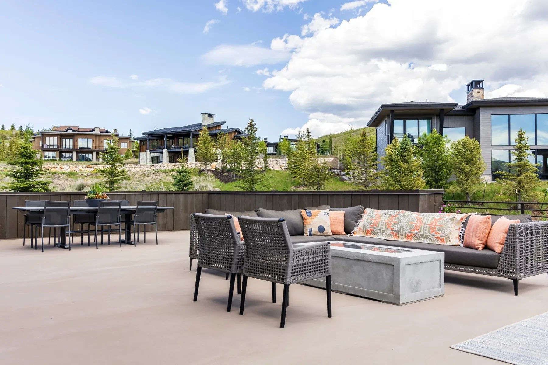 Expansive outdoor patio with a built-in fire feature and a privacy fence