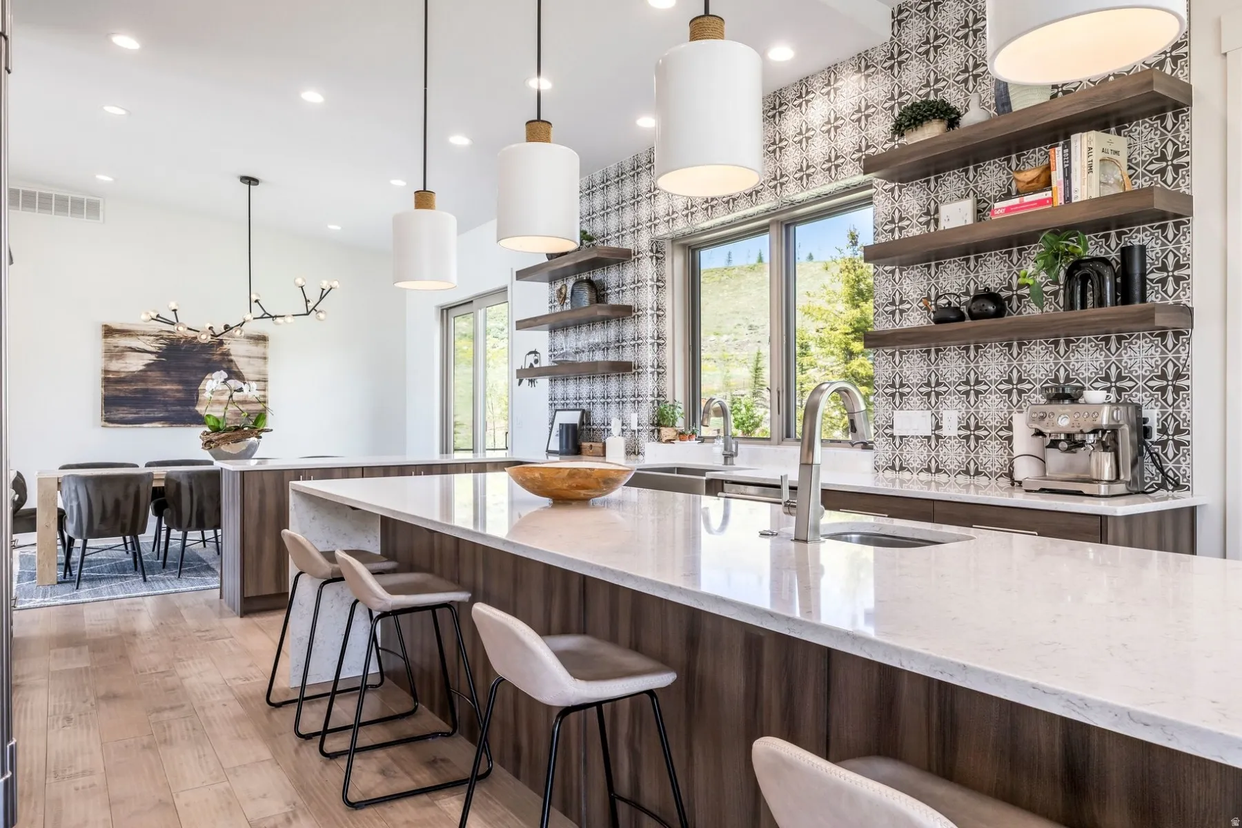 Kitchen featuring a large central island with seating, white countertops, wood-finish cabinetry, and a patterned tile backsplash