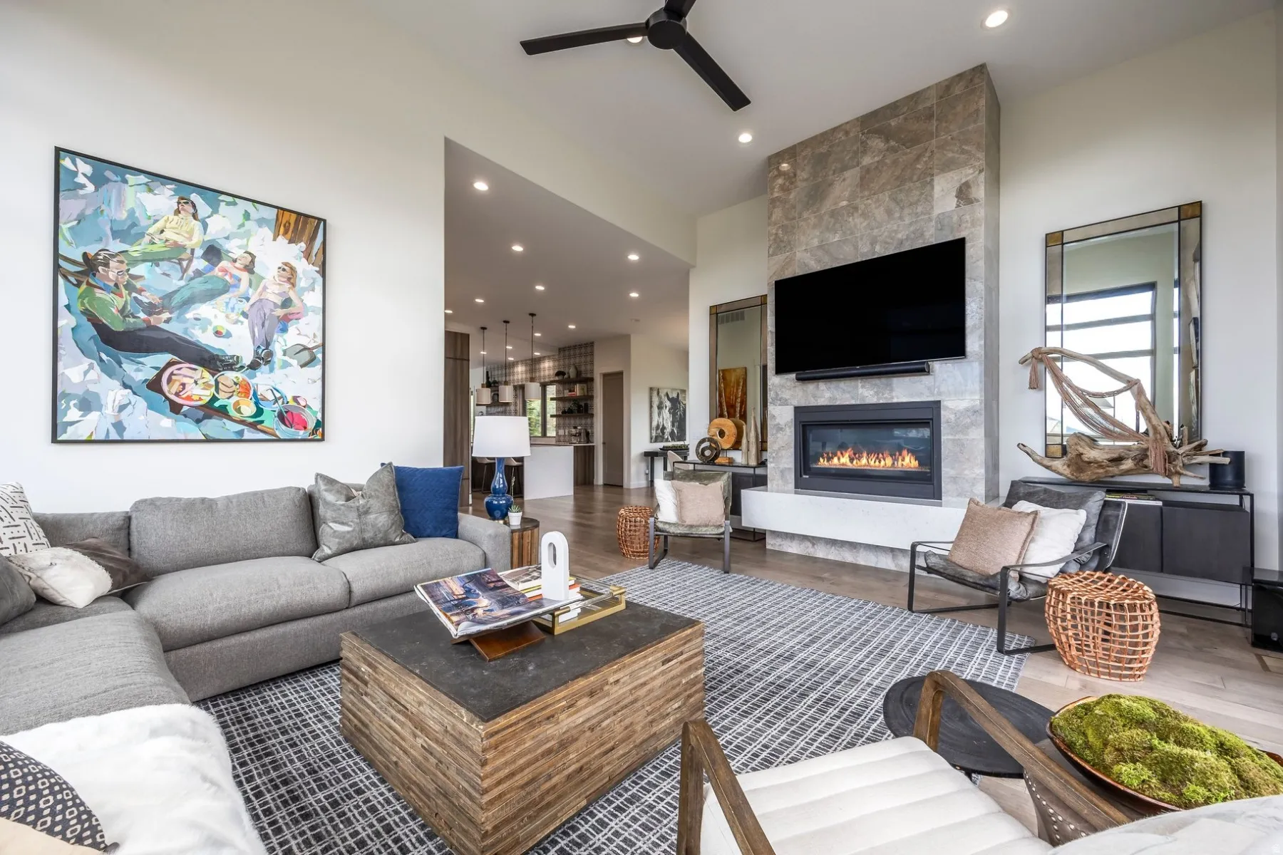 Spacious living area featuring a floor-to-ceiling stone-clad fireplace, built-in fireplace, recessed lighting, wood-finish flooring, and a ceiling fan