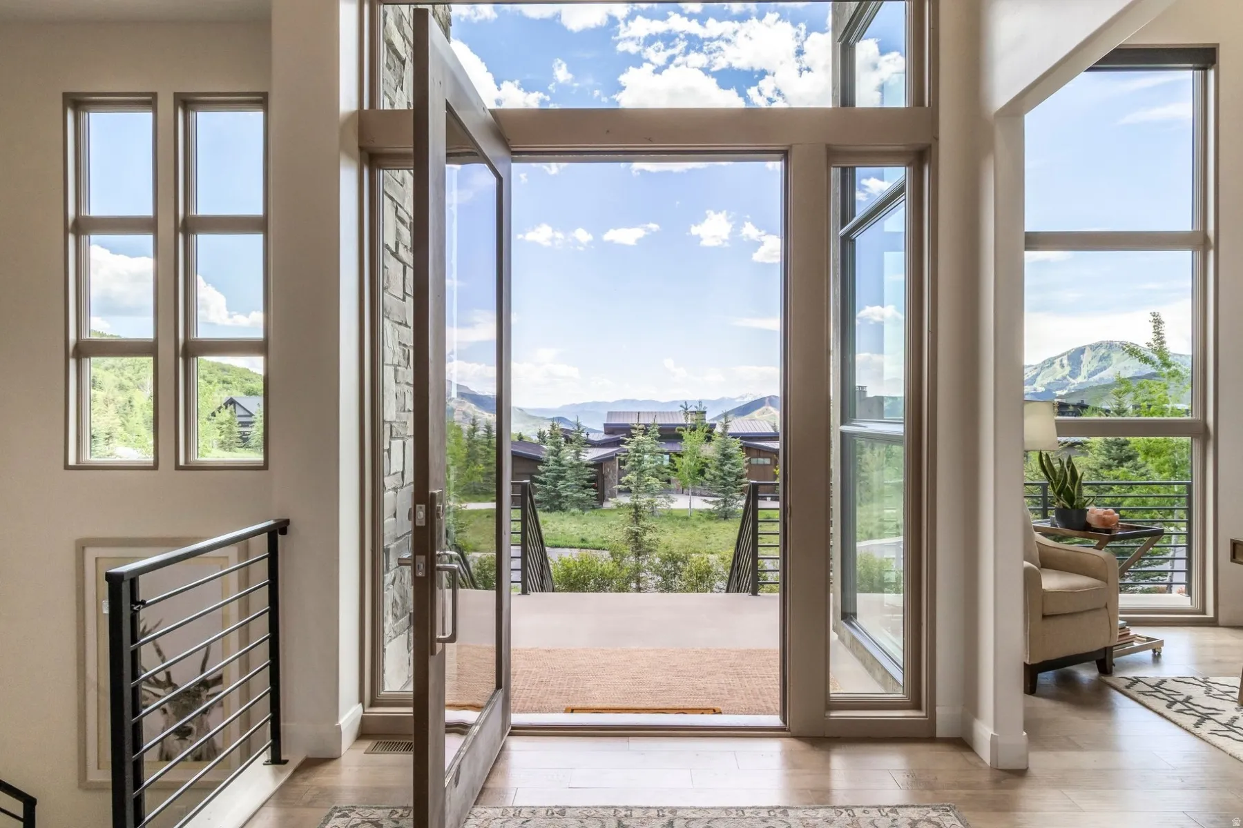 Expansive glass entry door with a stone surround, complemented by a tall transom window