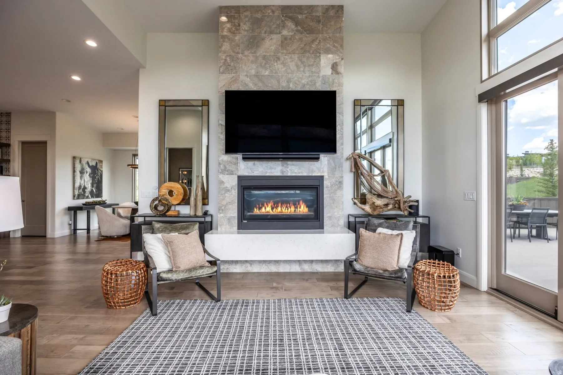 Stone-clad fireplace with a built-in firebox, wood-finish flooring, recessed lighting, and a glass sliding door