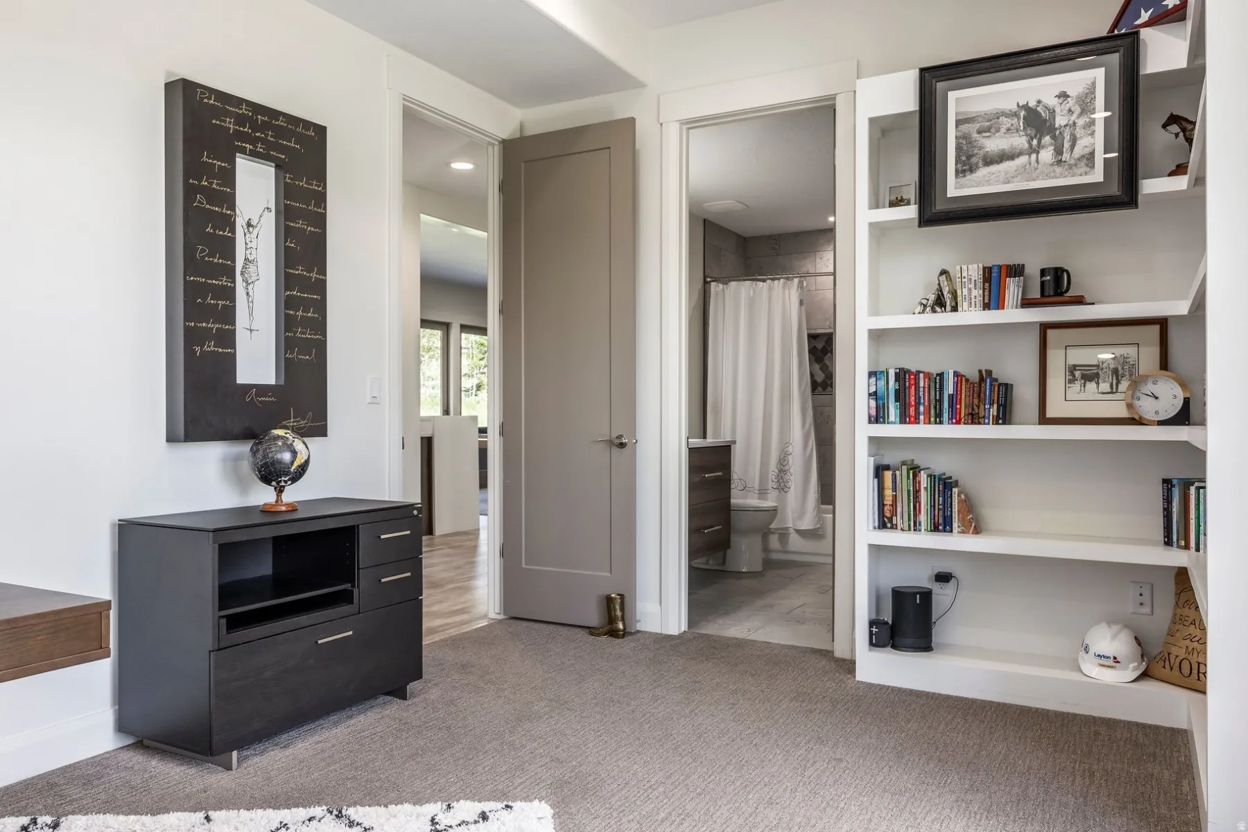 Built-in white shelving, recessed lighting, and a neutral carpeted floor