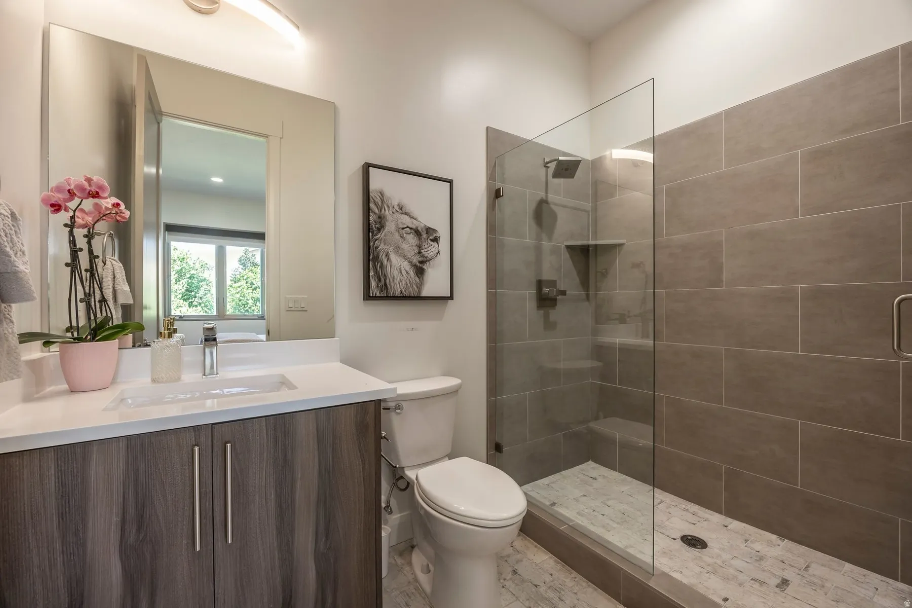 Modern vanity with a rectangular undermount sink, a glass-enclosed shower, and a built-in shower niche