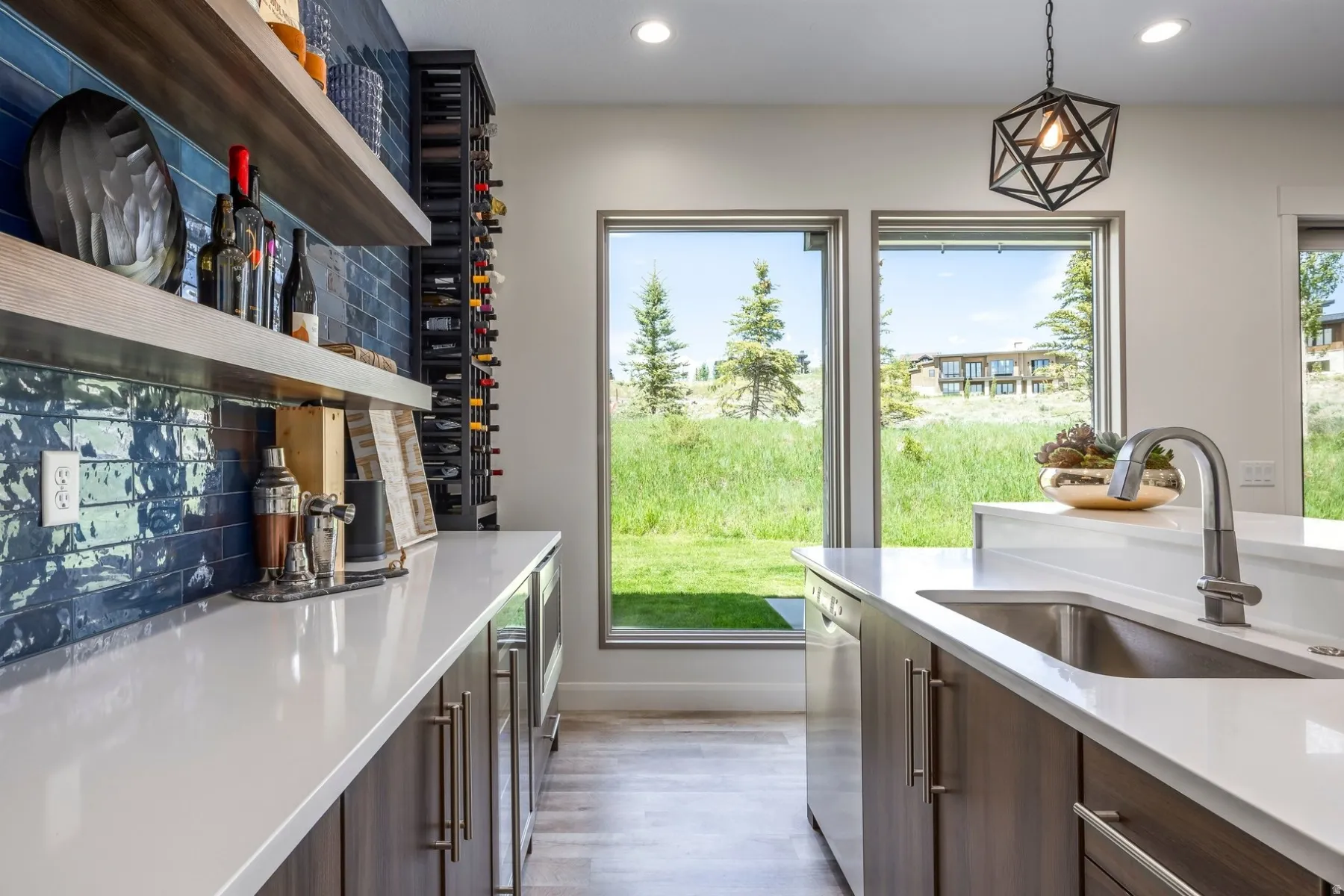 Integrated wet bar with floating wood-finish shelving and blue subway tile backsplash