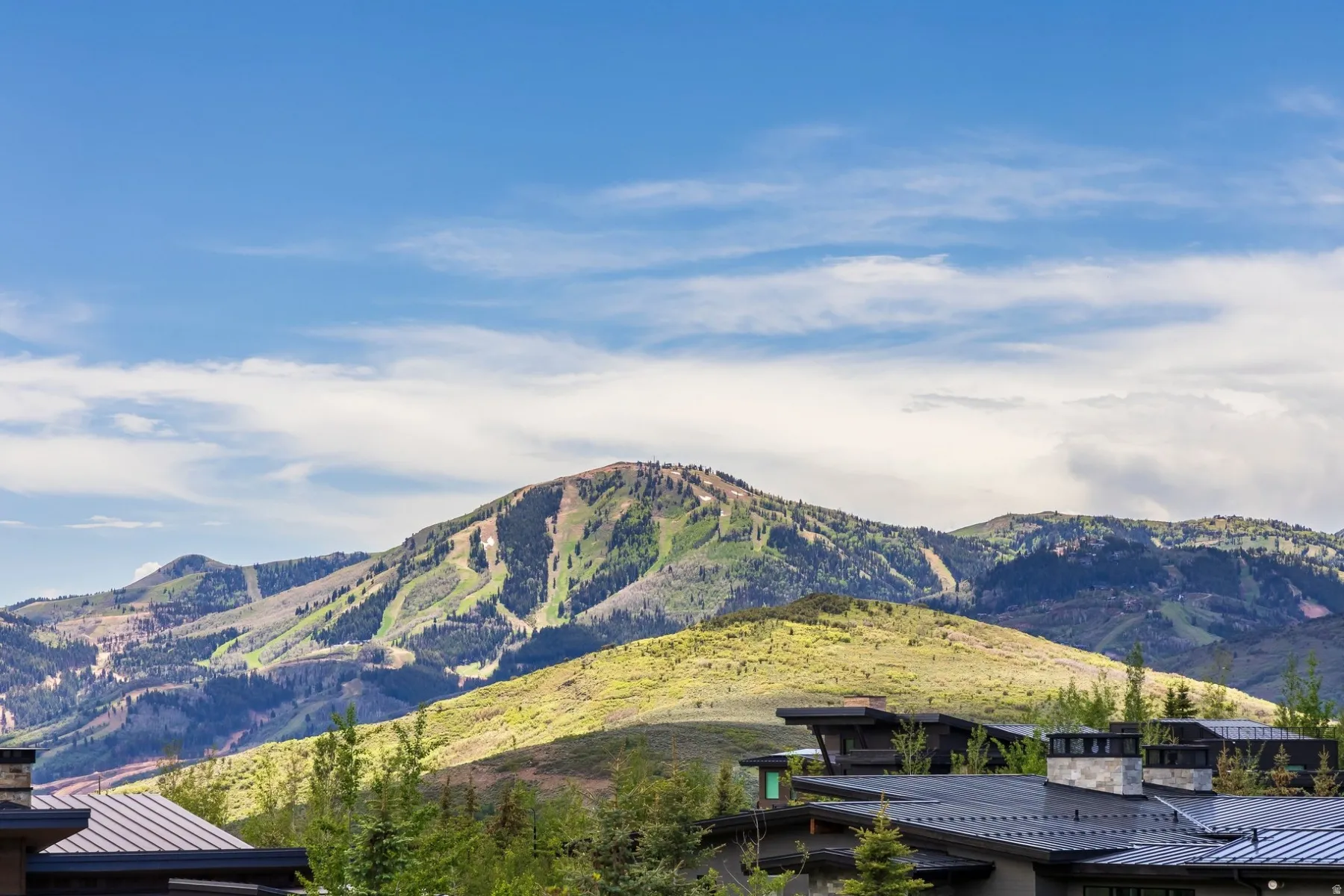 Mountain backdrop with multiple peaks and lush green slopes