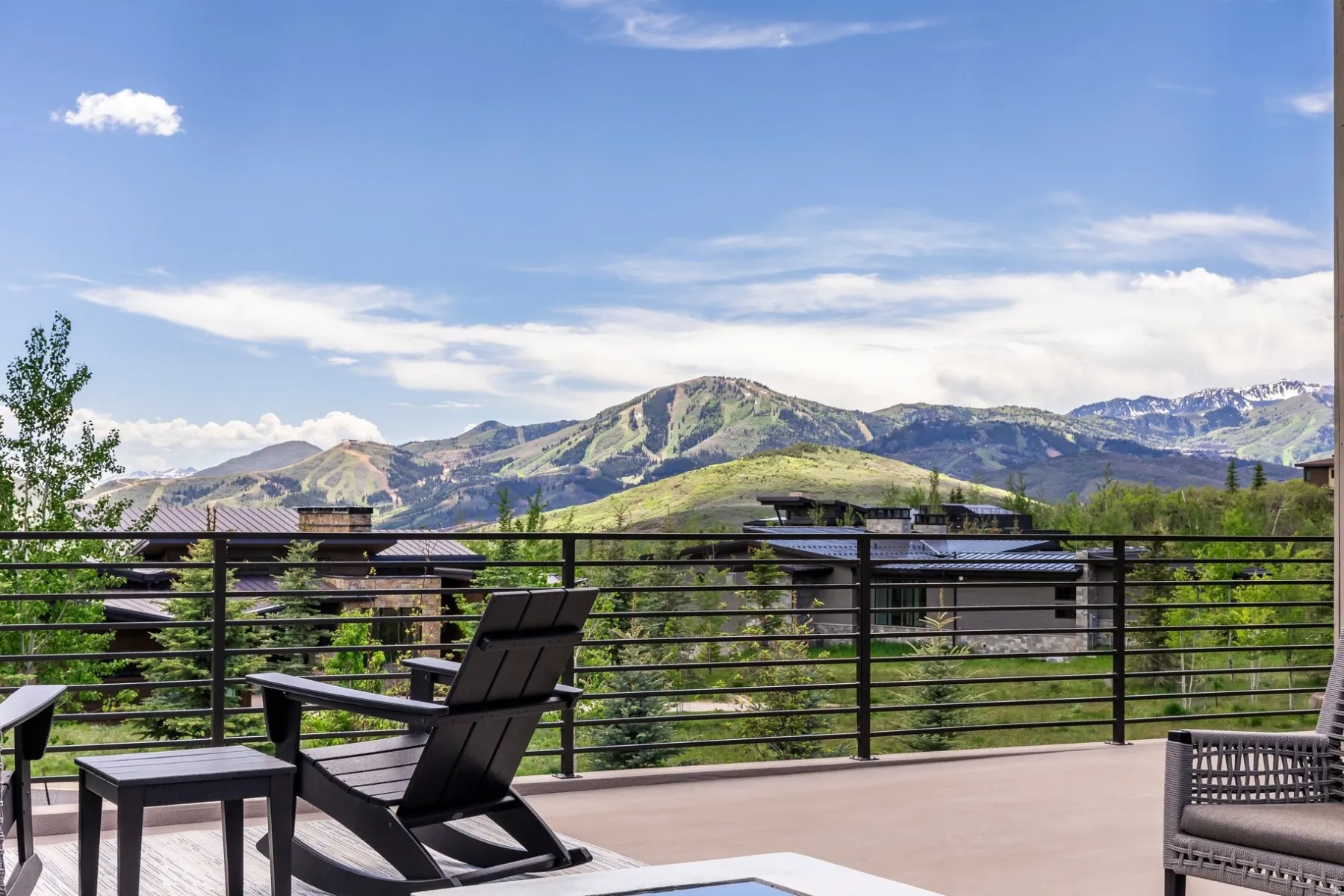 Spacious outdoor patio with mountain scenery, surrounded by mature trees