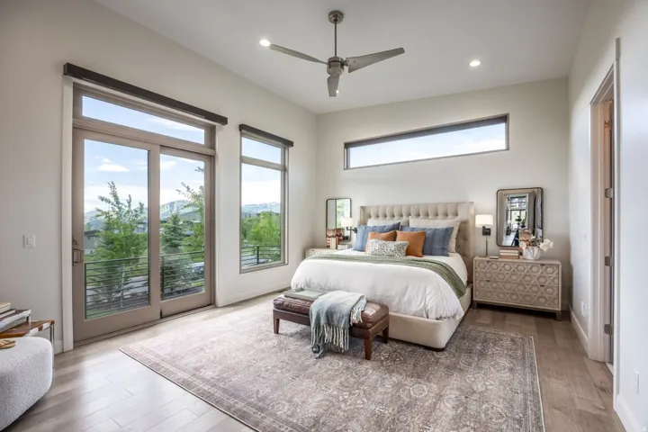 High ceilings with recessed lighting, a modern ceiling fan, and large sliding glass doors opening to an exterior railing