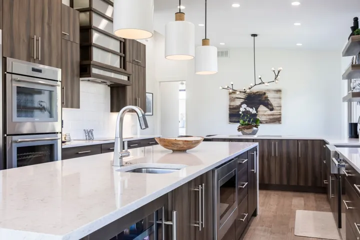 Spacious kitchen featuring a large island with an undermount sink, integrated microwave, and beverage cooler