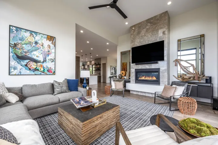 Spacious living area featuring a floor-to-ceiling stone-clad fireplace, built-in fireplace, recessed lighting, wood-finish flooring, and a ceiling fan