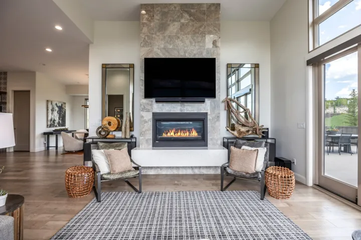 Stone-clad fireplace with a built-in firebox, wood-finish flooring, recessed lighting, and a glass sliding door