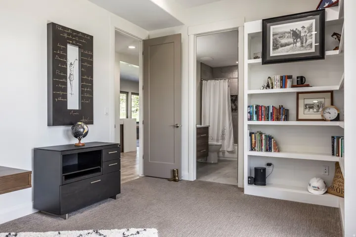 Built-in white shelving, recessed lighting, and a neutral carpeted floor