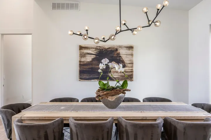 Natural wood-finish flooring, modern linear chandelier, and recessed lighting