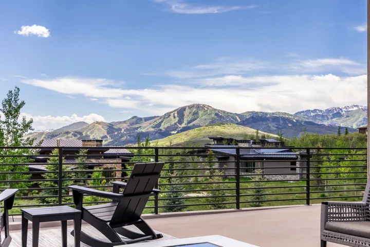 Spacious outdoor patio with mountain scenery, surrounded by mature trees