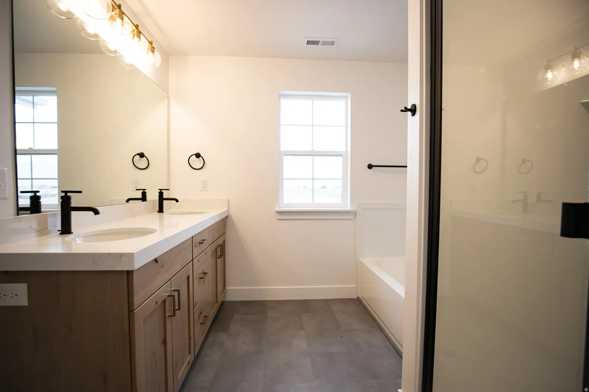 Primary bathroom featuring dual vanity and separate tub and shower