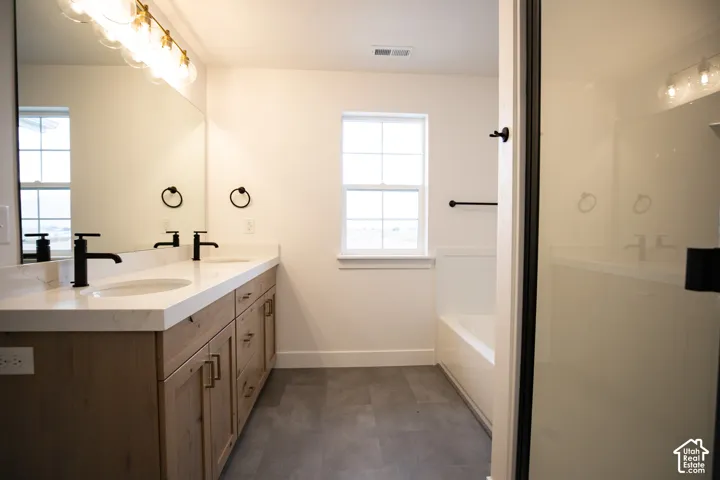 Primary bathroom featuring dual vanity and separate tub and shower