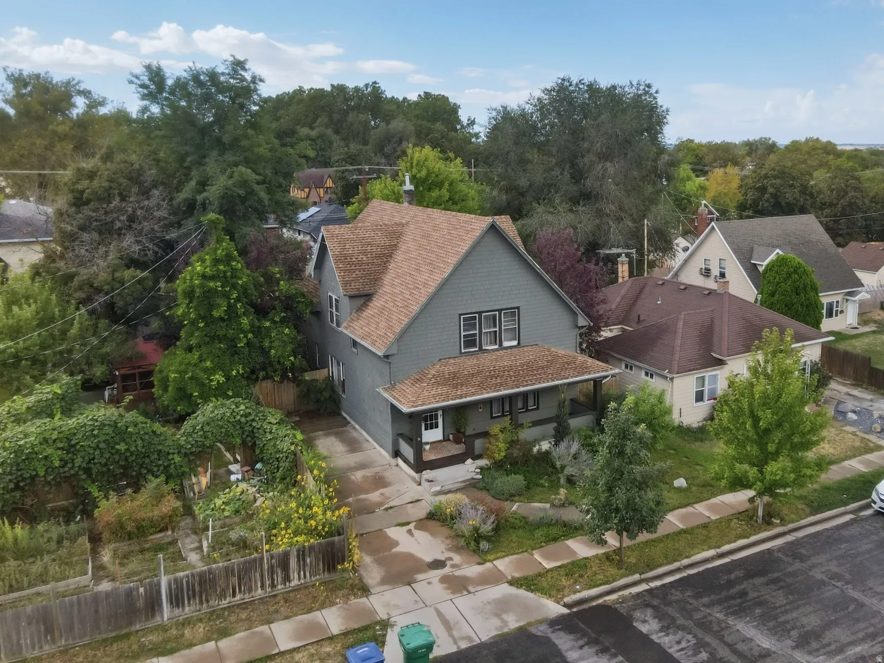 Multi-level architecture with a covered front porch, asphalt shingle roof, and a paved driveway.