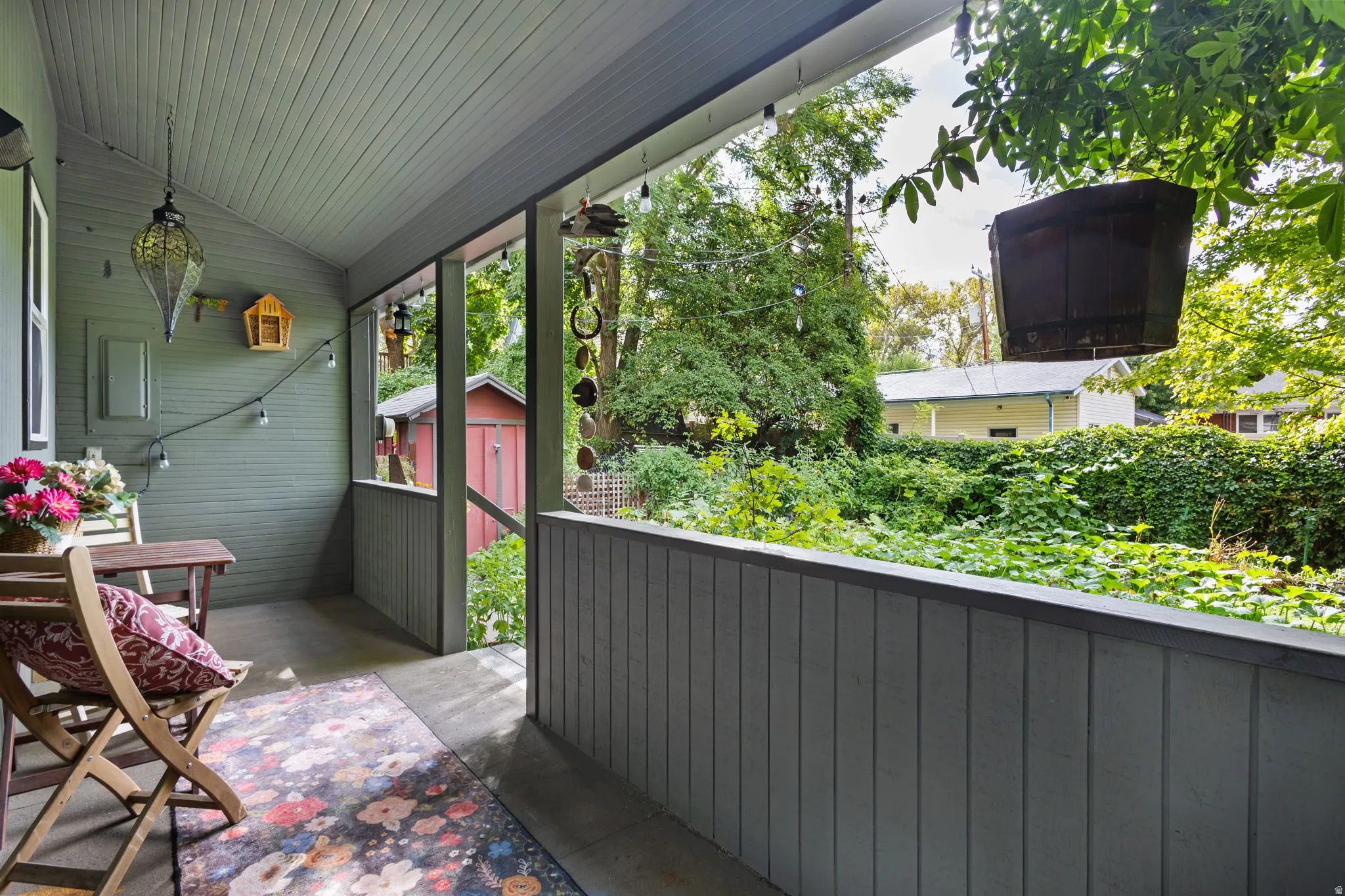Covered porch with painted wood siding and paneled ceiling.