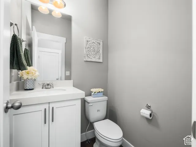Modern vanity featuring white cabinetry, a light-toned countertop with integrated sink, and a chrome faucet