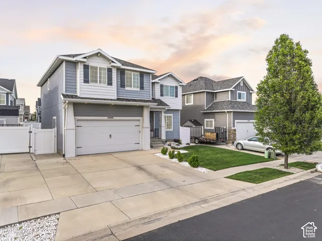 Two-story residence featuring a two-car garage, gray siding with white trim, and a prominent front entrance