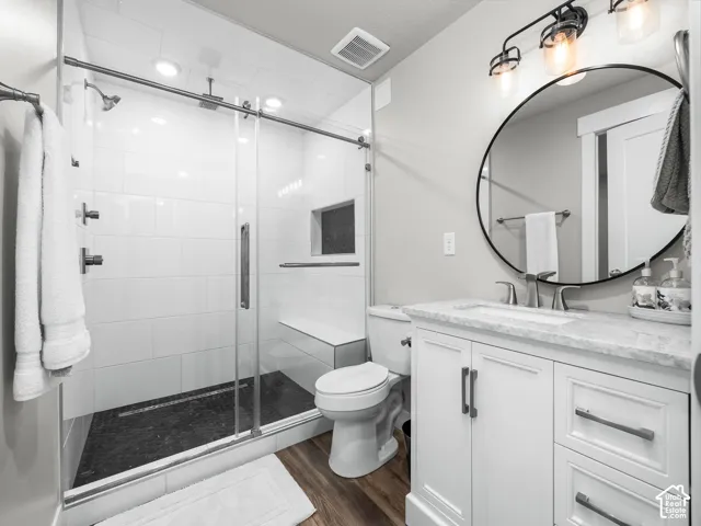 Modern bathroom featuring a glass-enclosed shower with white subway tile, a dark-toned shower pan, and a built-in bench