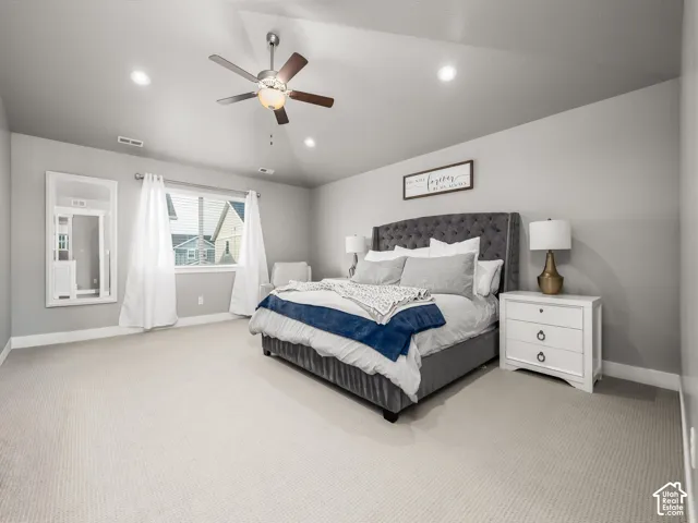 Spacious room featuring vaulted ceilings, recessed lighting, a ceiling fan, light gray wall tones, and plush carpet flooring