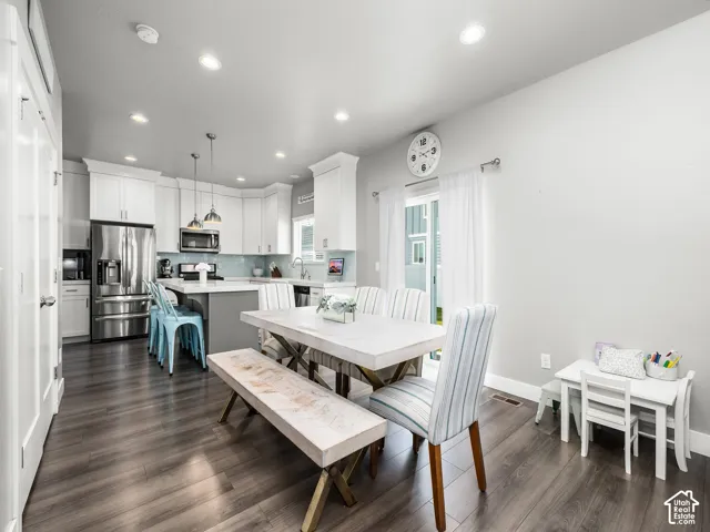 Open-concept kitchen and dining area featuring wood-finish flooring, recessed lighting, and a sliding glass door