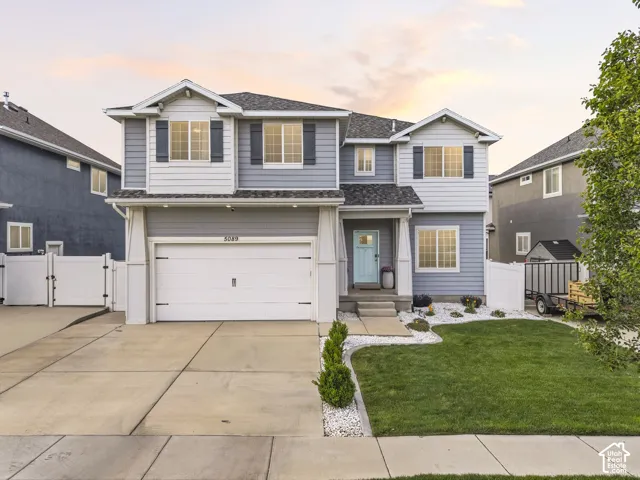 Two-story residence featuring light blue siding with white trim accents and dark shutters