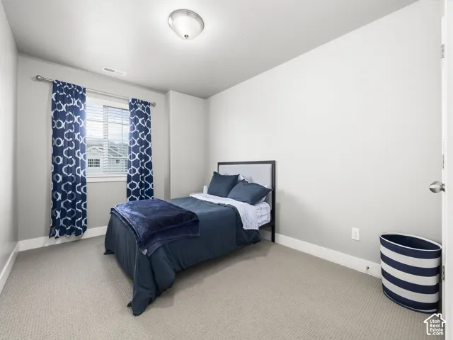 Carpeted room with a window featuring horizontal blinds, recessed baseboard trim, and a flush-mount ceiling light