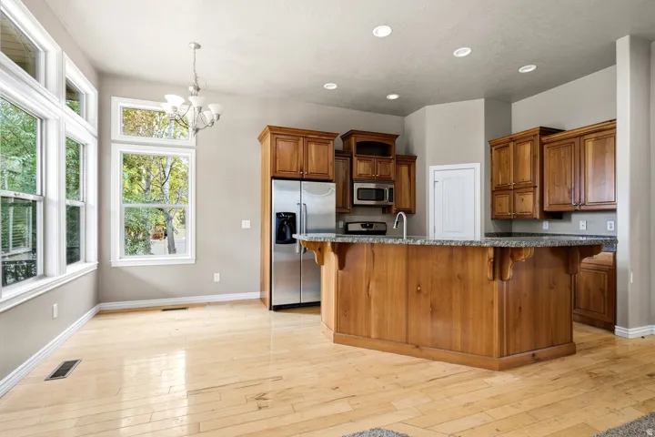 Wood-finish flooring throughout, complemented by a kitchen island with stone countertop