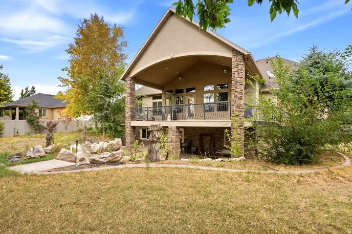 Two-story exterior with a stone-clad lower level and an upper-level covered balcony featuring a metal railing