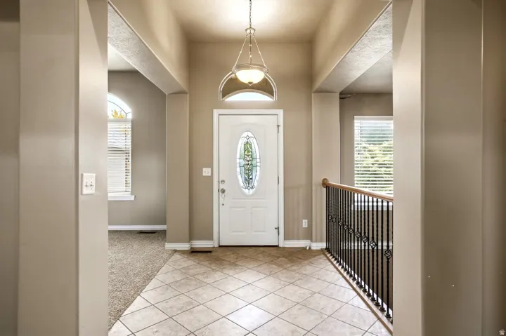 Entryway featuring tiled flooring, a decorative front door with stained glass, and an overhead pendant light fixture