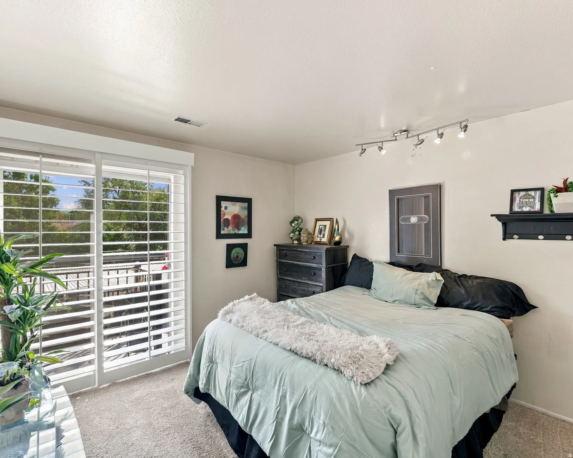 Sliding glass door with full-height white plantation shutters