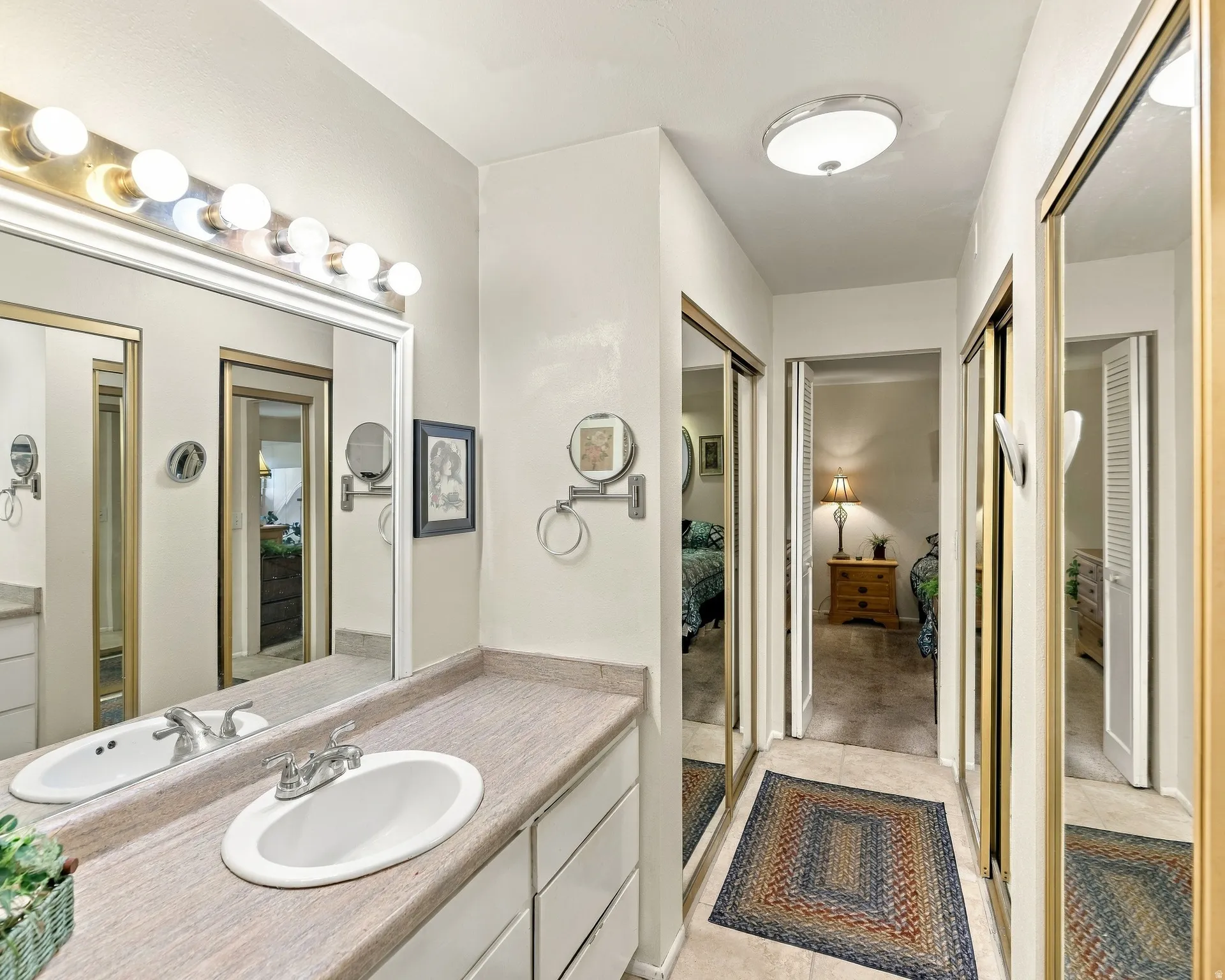 Vanity with integrated sink, expansive mirror, and a multi-bulb light fixture