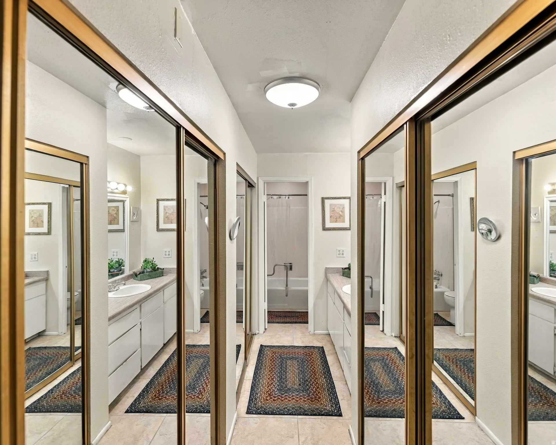 Hallway with mirrored closet doors, tile flooring, and flush-mount ceiling lighting