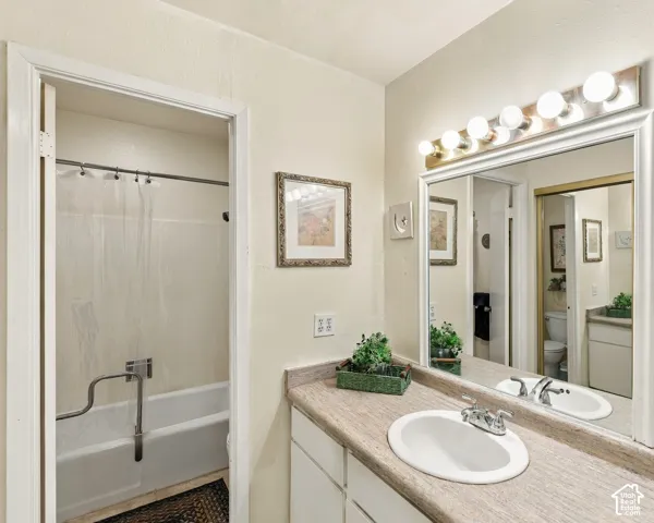 Bathroom featuring a vanity with a white oval sink, chrome faucet, and a large wall-mounted mirror