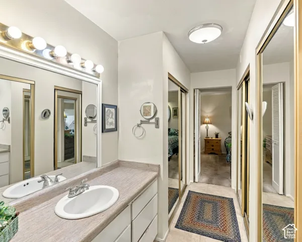Vanity with integrated sink, expansive mirror, and a multi-bulb light fixture