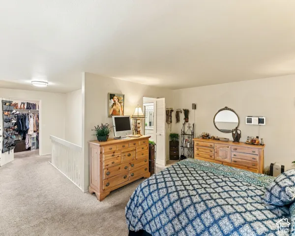 Carpeted flooring throughout, recessed ceiling lighting, and a white interior railing