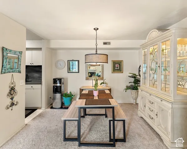 Recessed lighting, neutral wall tones, a built-in display cabinet with glass-paneled doors, and a decorative pendant light with a drum shade