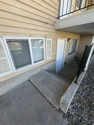 Exterior entry with concrete steps and a black metal railing