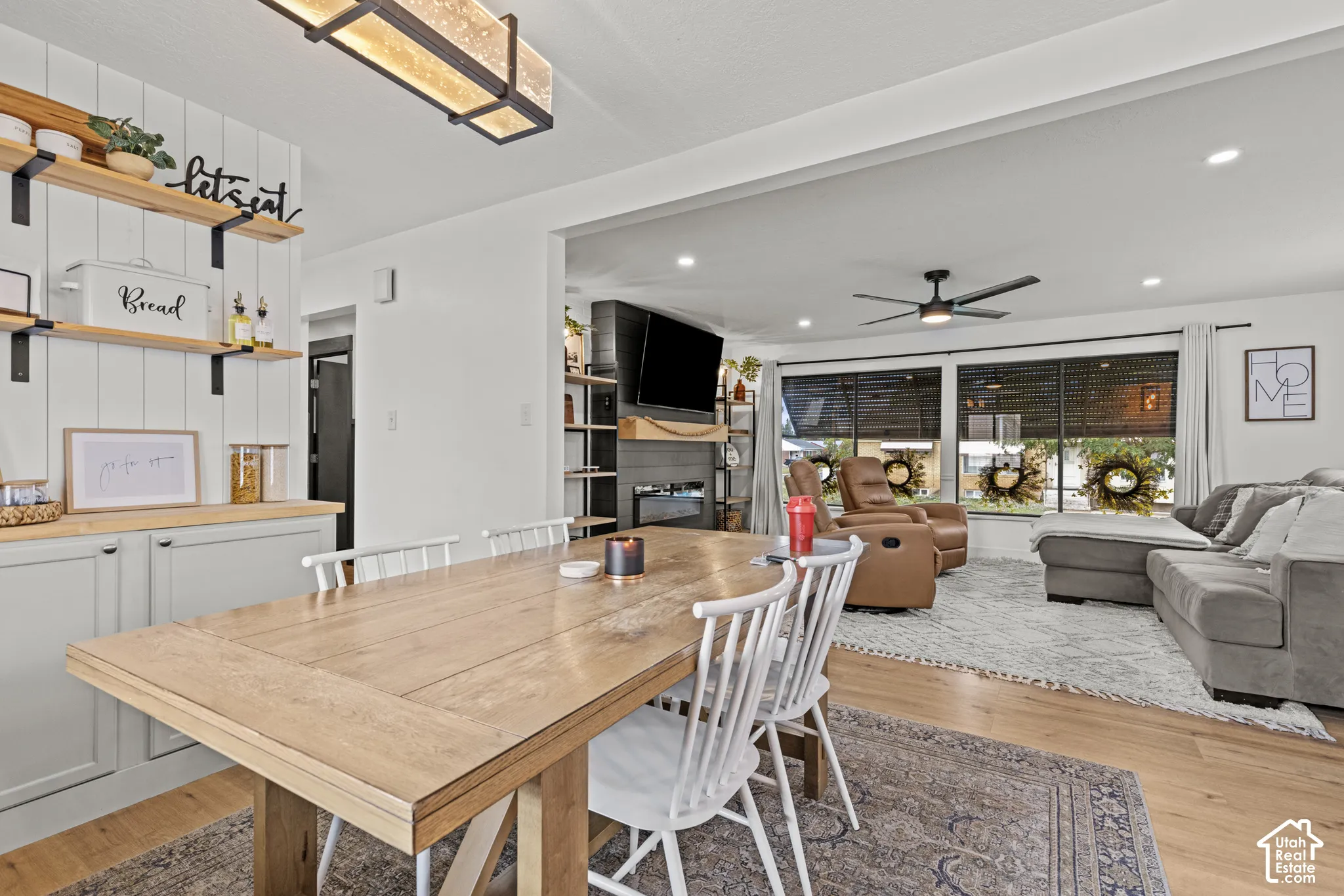 Dining area featuring wood-finish flooring, built-in cabinetry with light-toned countertops, and open shelving