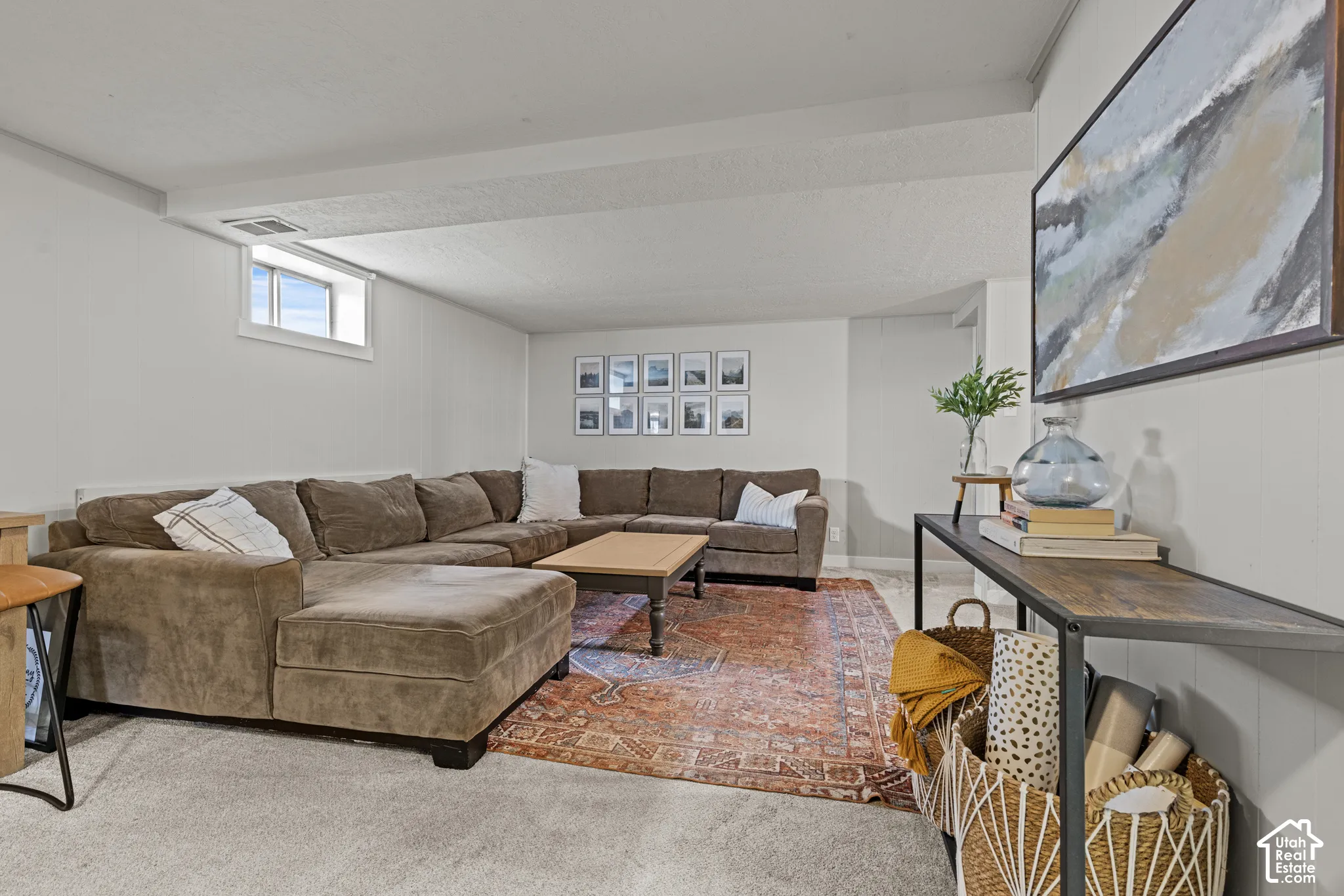 Recessed window, painted white walls, wood-finish console table, and carpeted flooring